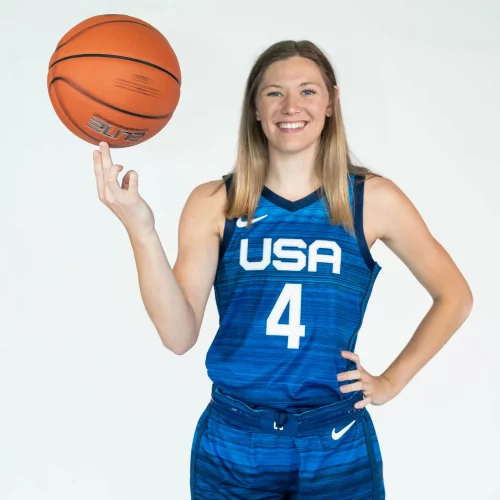 USA female athlete holding basketball for sports media portrait.