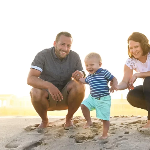 Family walking along beach during lifestyle photography session.