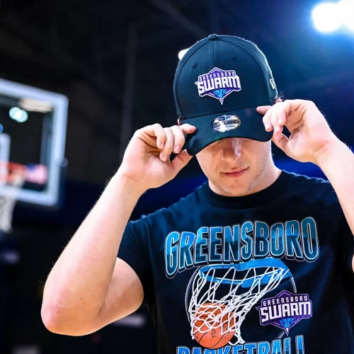 Person modeling a team hat for the Greensboro Swarm NBA G-League professional portrait session for merchandising.