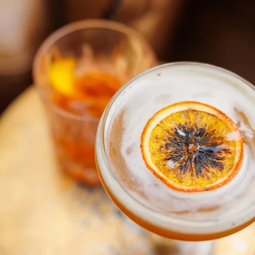 Old fashioned cocktail topped with orange peel captured for beverage branding.