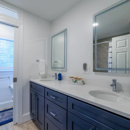 Modern bathroom vanity with navy cabinets and chrome fixtures for real-estate listings.