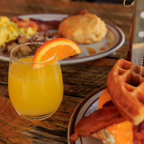 Brunch setup with waffles and mimosa during a restaurant lifestyle shoot for menu offerings.