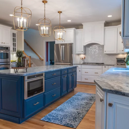 Modern kitchen with blue island and pendant lighting captured for real estate photography.