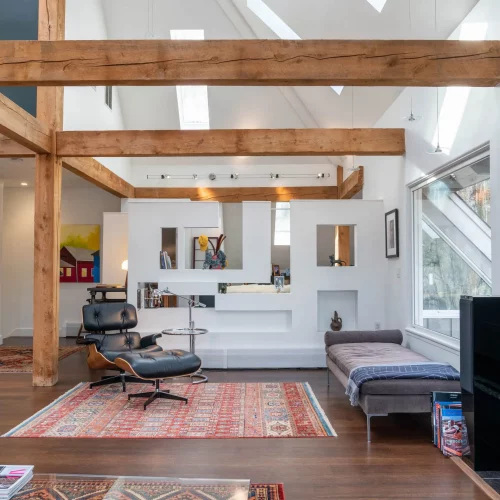 Modern interior with wood support beams and black tile accents for a real estate website header image.