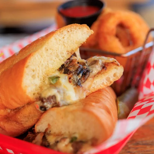 Signature sandwich and fries plated for commercial food photography.