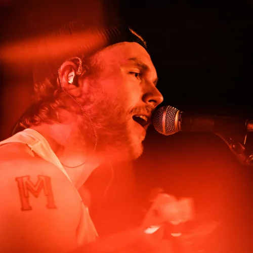 Singer performing live with microphone under red lighting in Myrtle Beach, SC.