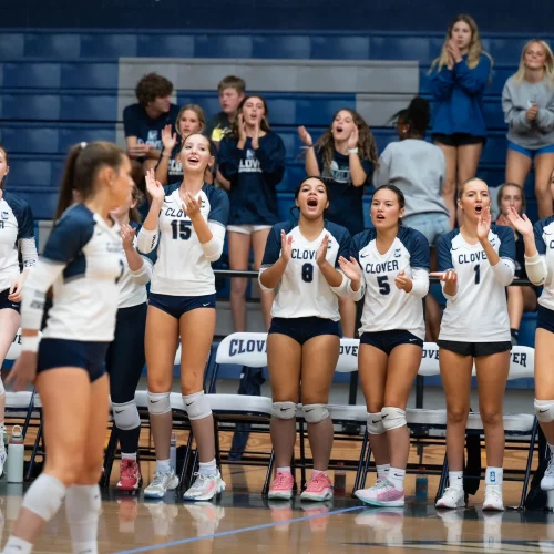 High school volleyball team cheering on sidelines during a home game covered by MJS Live Productions.