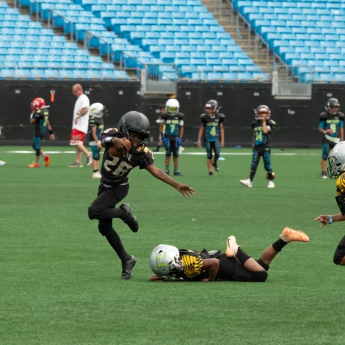 Football tackle captured mid-game during event coverage by MJS Live Productions.