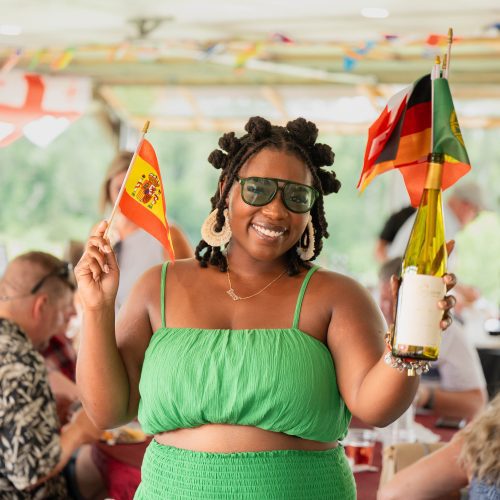 Cultural festival attendee waving flags during event coverage by MJS Live Productions